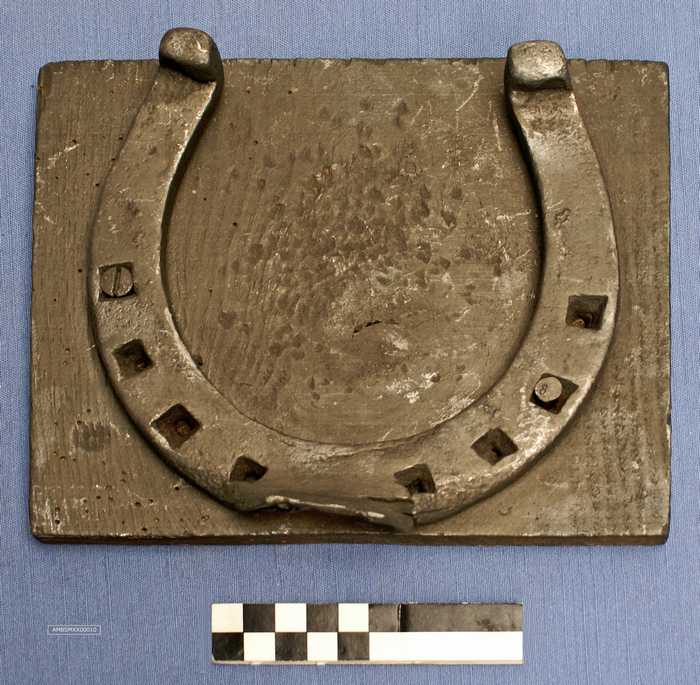 Hoefijzer op houten plank