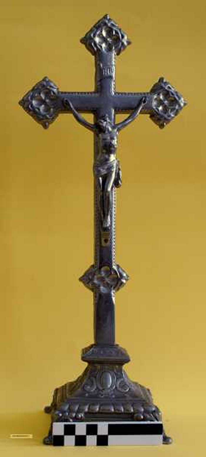 Metalen kruisbeeld op sokkel