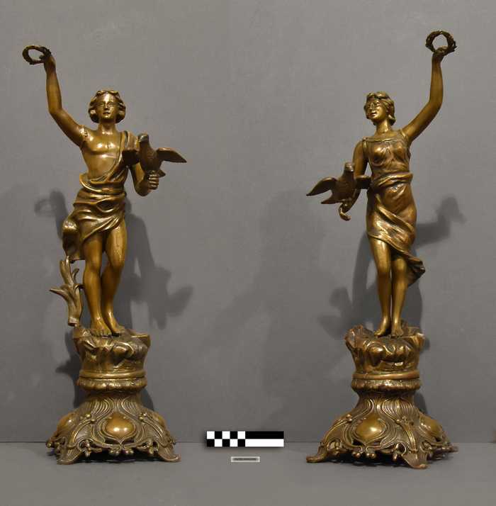 Set van twee sierbeelden - Man en vrouw in gewaad met duif en lauwerkrans in de hand