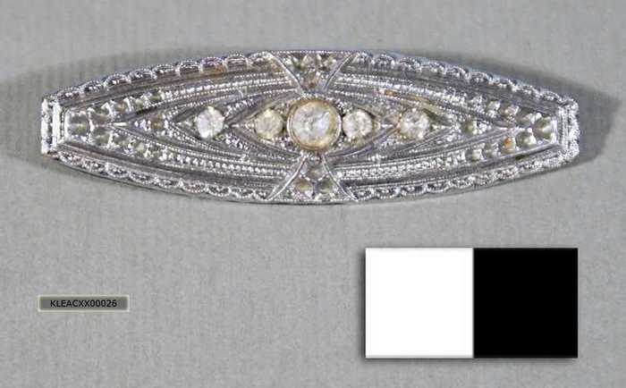 Sierspeld: Zilverkleurige broche met witte steentjes