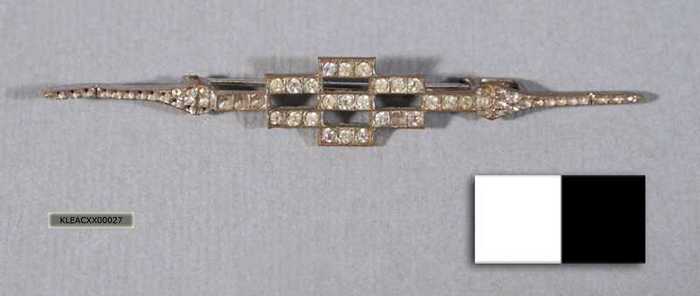 Sierspeld: Zilverkleurige broche met witte steentjes