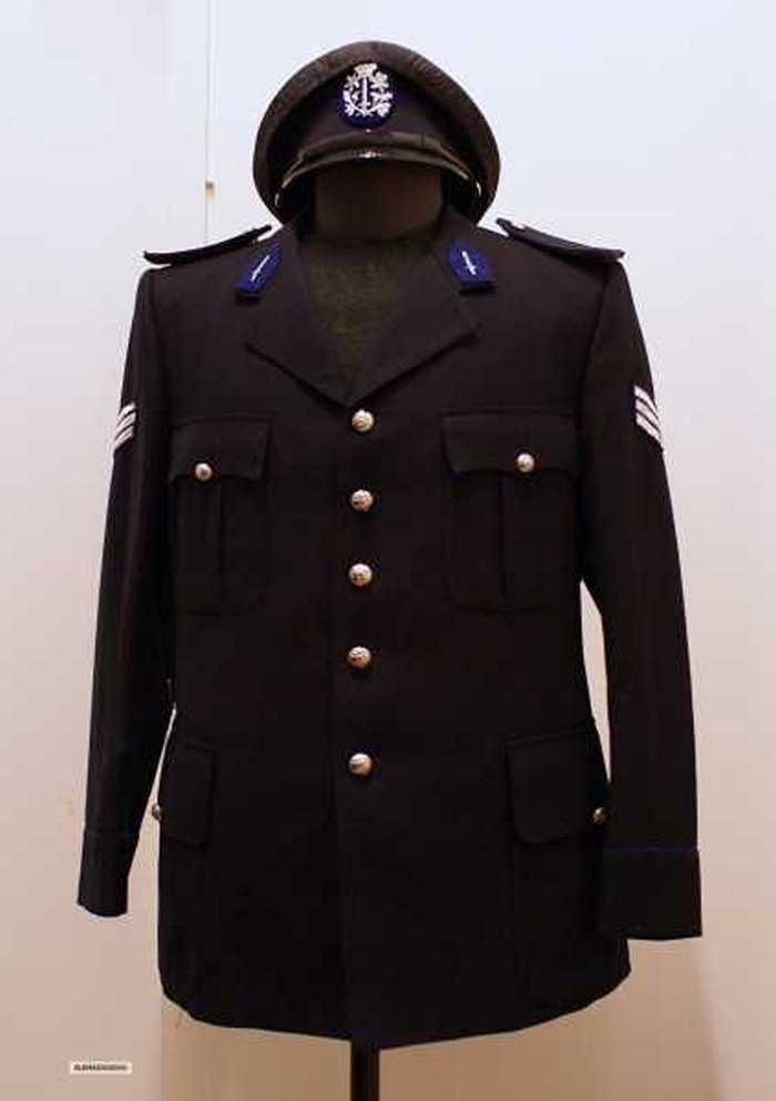 Politiekostuum met das, riem en kepie.