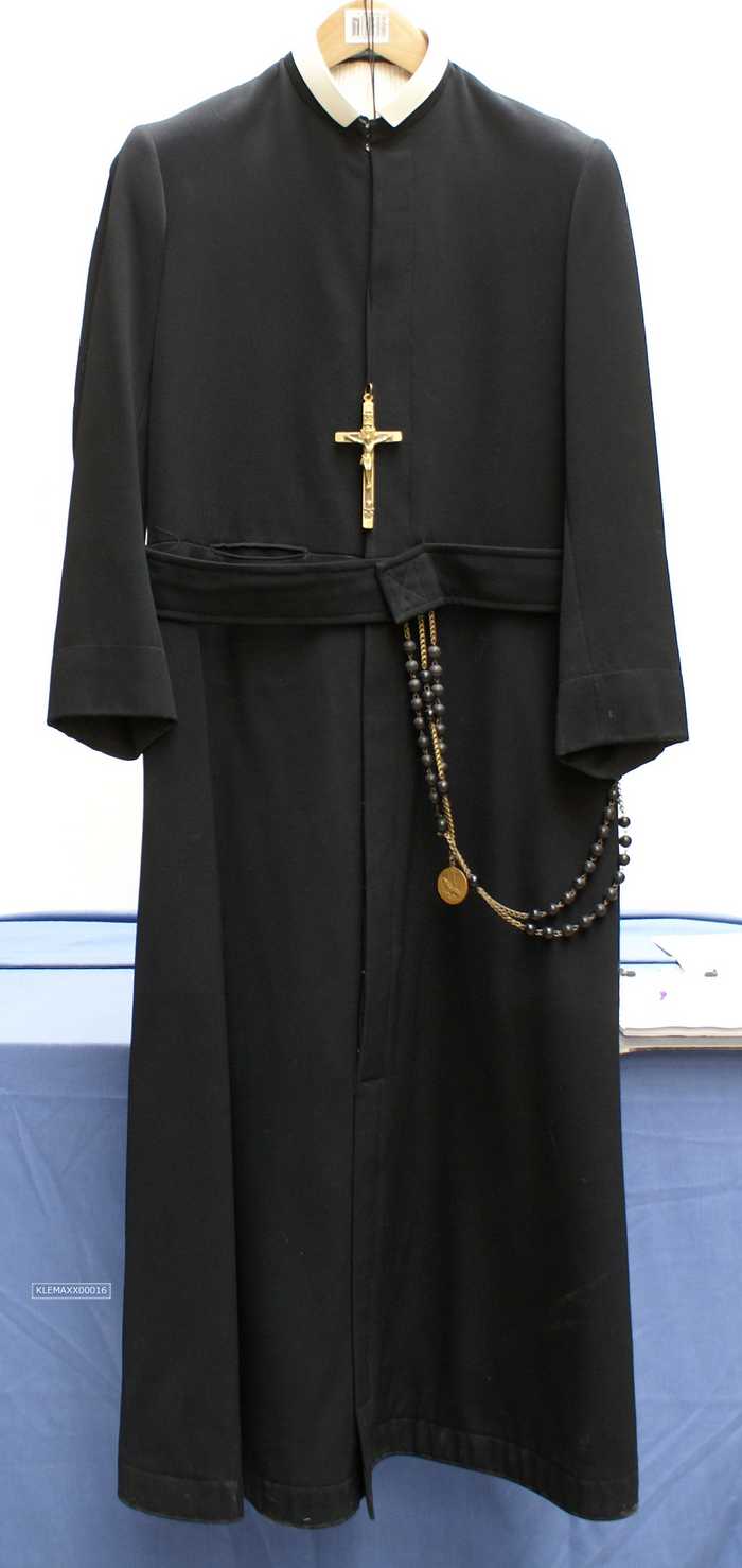 Zwarte soutane met witte boord, koperen kruis en rozenkrans