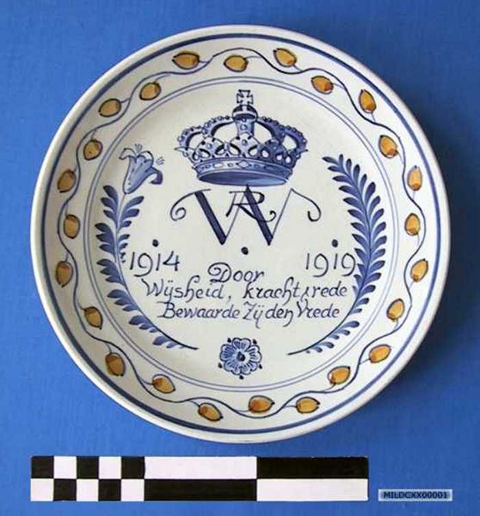 Sierbord in keramiek met afbeelding Koninklijke kroon, `DOOR WIJSHEID, KRACHT EN REDE BEWAARDE ZIJ DEN VREDE 1914-1919