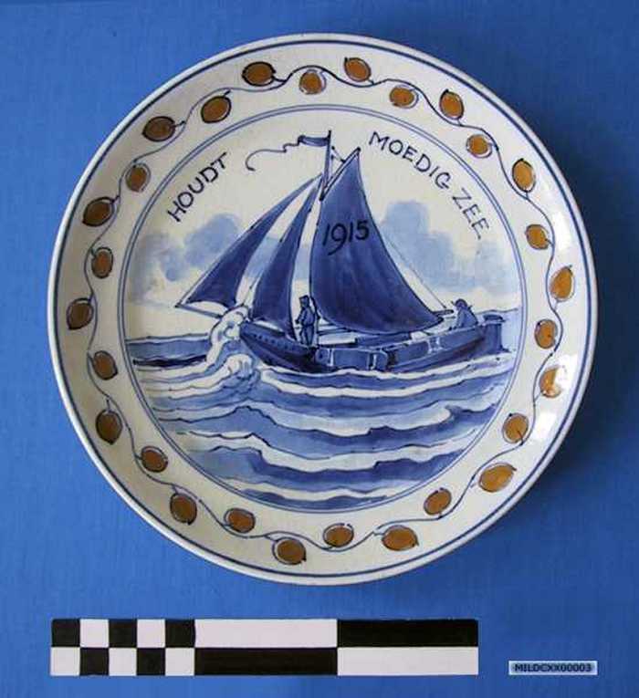 Sierbord in keramiek met afbeelding van een vissersboot op zee, `HOUDT MOEDIG ZEE -  1915