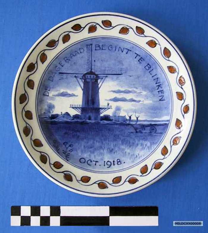 Sierbord in keramiek met afbeelding van een landschap, `DE DAGERAAD BEGINT TE BLINKEN - OCT 1918