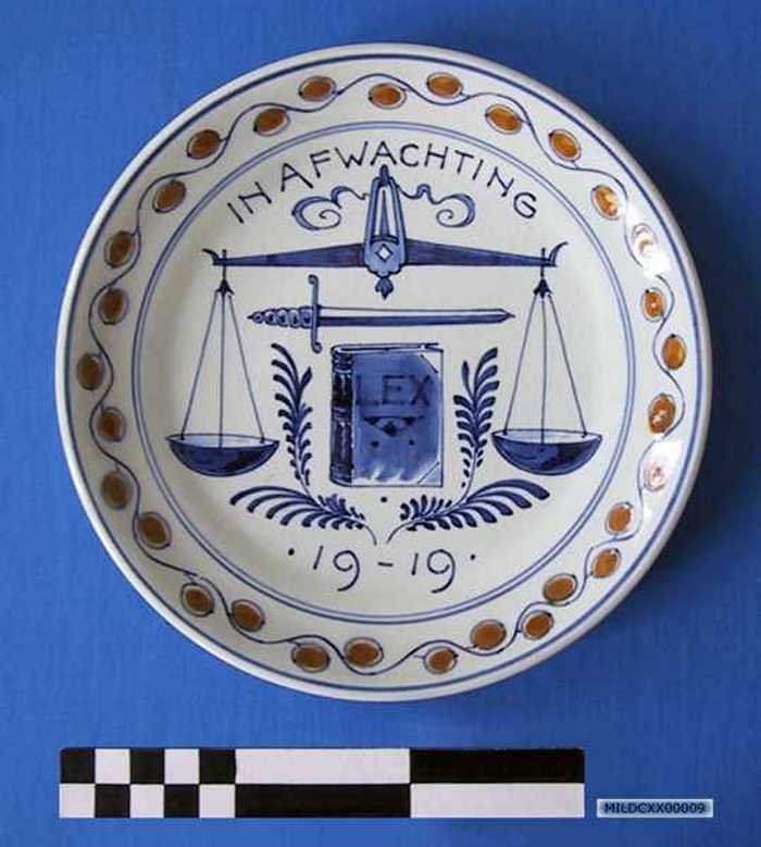 Sierbord in keramiek met afbeelding van een weegschaal, zwaard en boek, `IN AFWACHTING - 1919